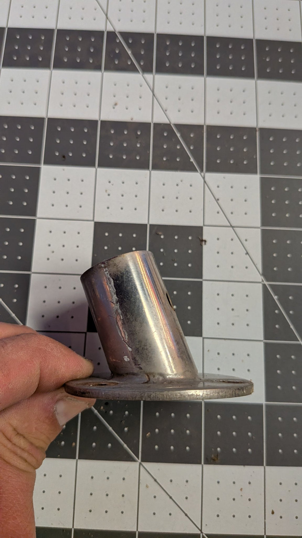 Angled view of stainless stanchion base held in hand