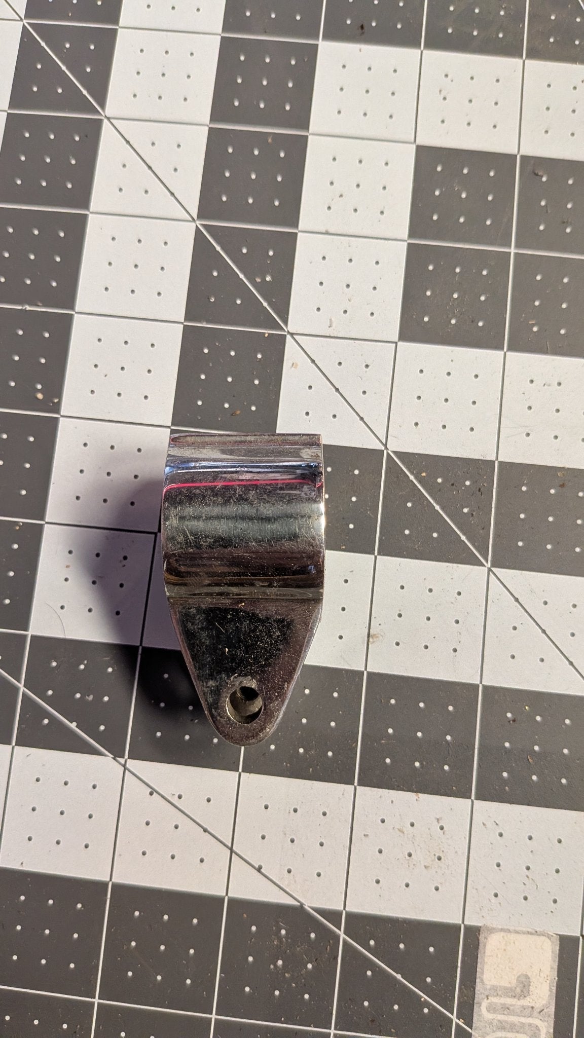 Stainless hinged jaw slide with forked tang side view on 1-inch grid