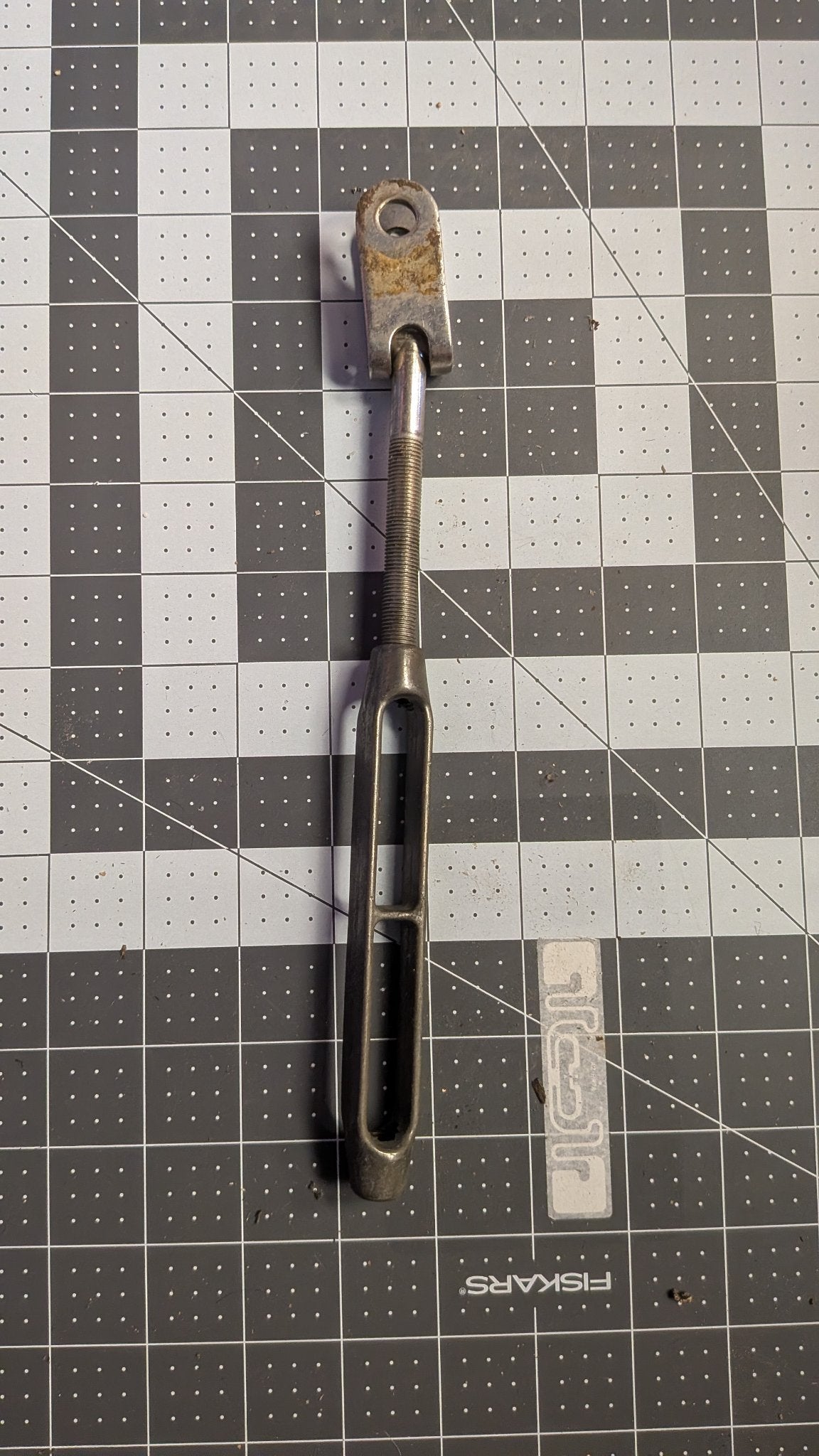 Reverse view of turnbuckle showing threaded stud on 1-inch grid