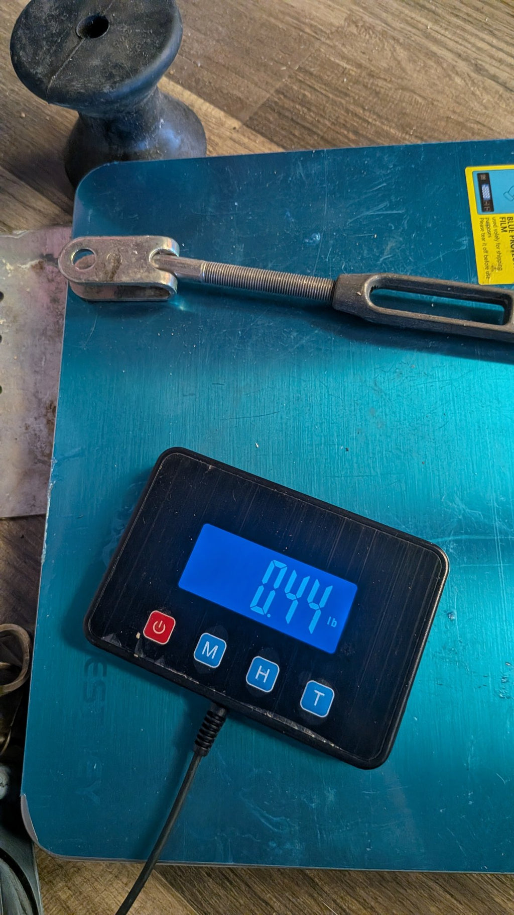 Turnbuckle on scale showing 0.44 lb