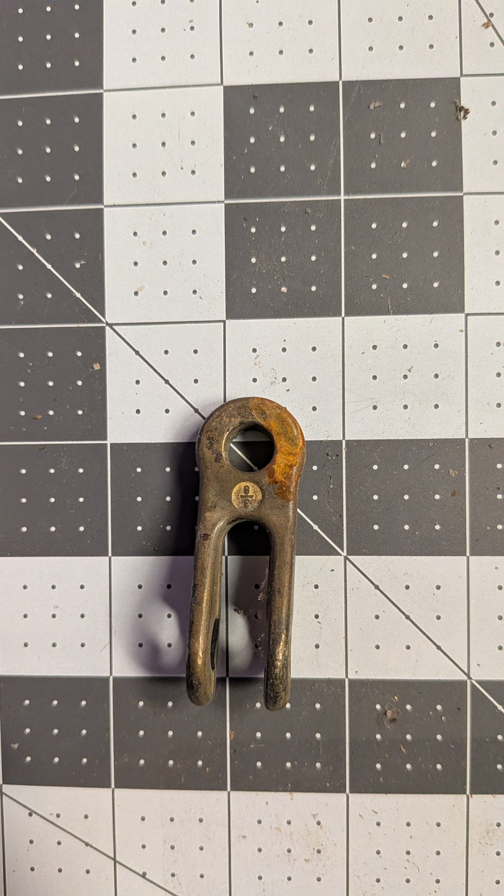 Bronze toggle showing patina on eye, angled on 1-inch grid