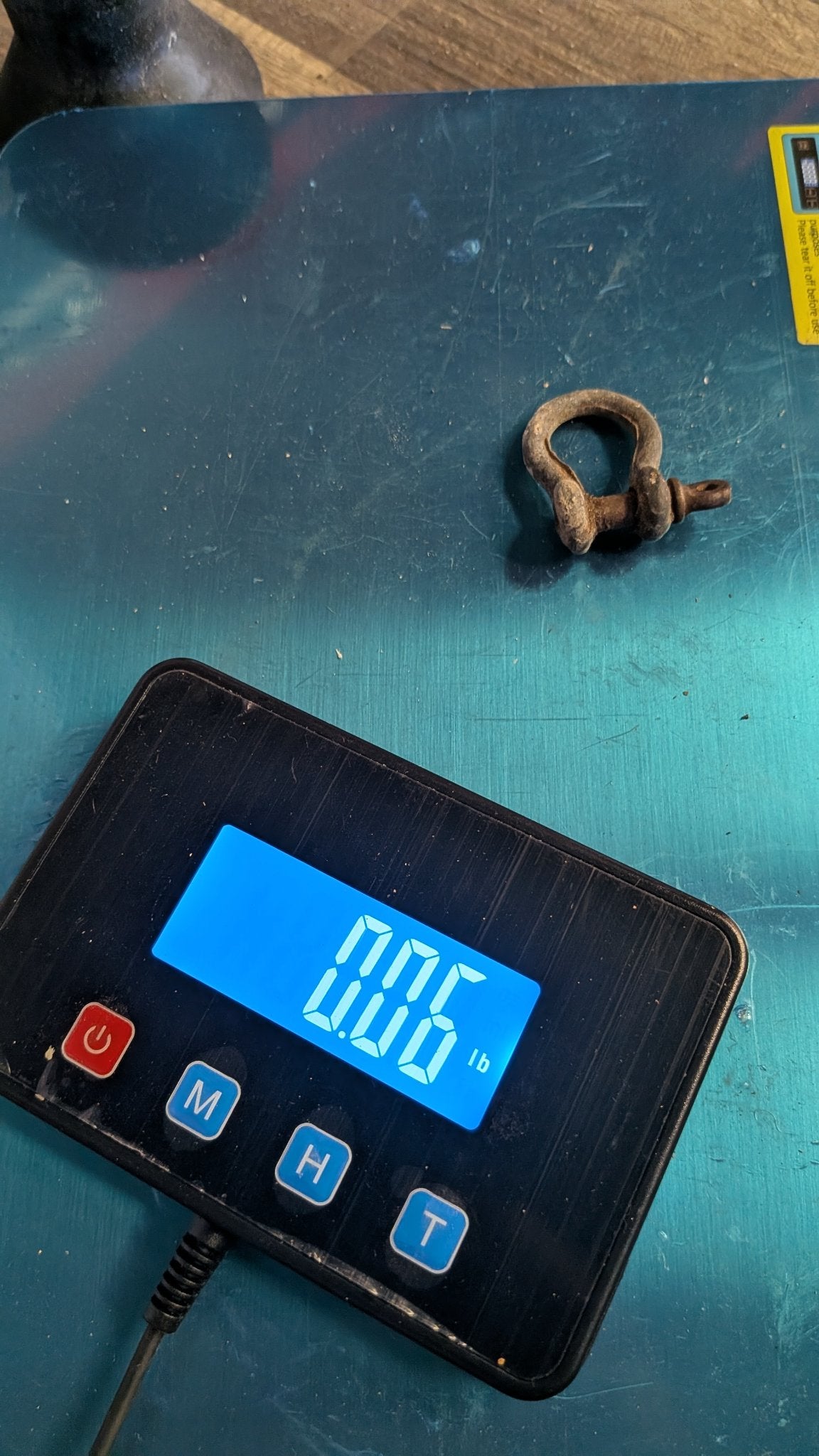 Bow shackle on scale showing 0.06 lb