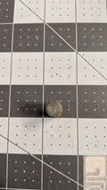 End view of bronze pivot pin on 1-inch grid