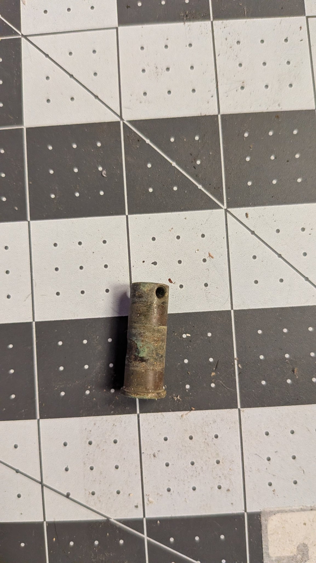 Bronze pivot pin side view with cross-drilled hole on 1-inch grid