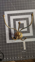 Brass 4-arm swivel coat hook front view on 1-inch grid