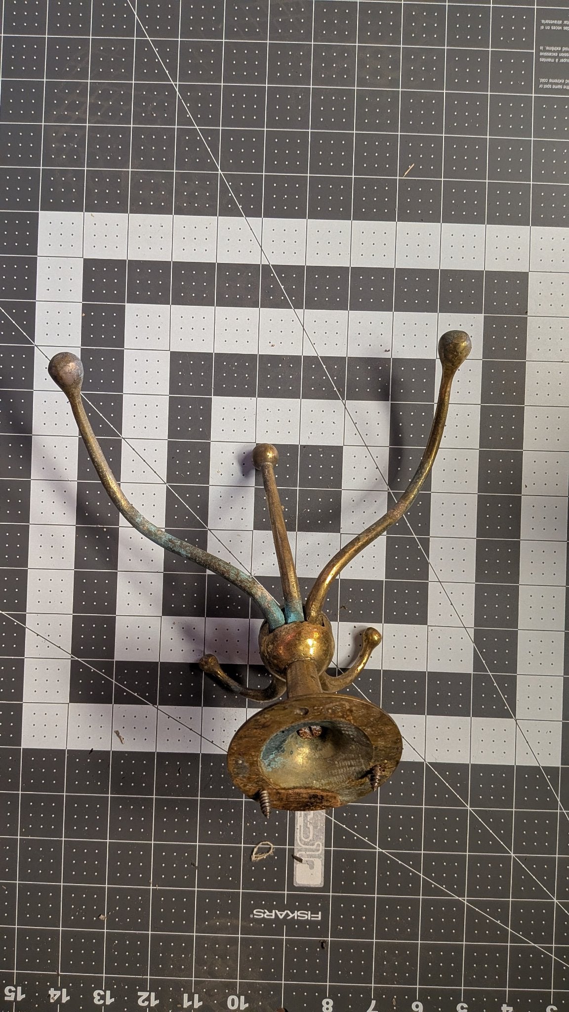 Side view of brass coat hook on 1-inch grid