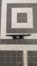 Black nylon dock cleat side view on 1-inch grid