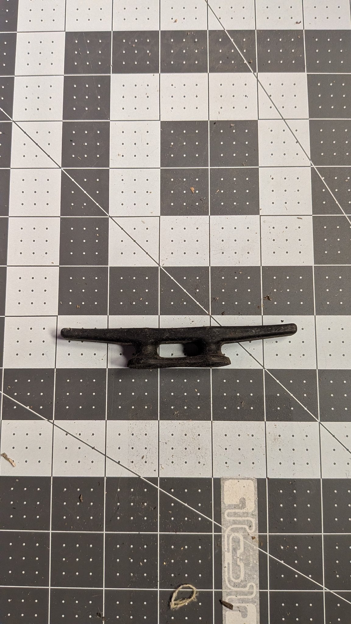 Black nylon dock cleat side view on 1-inch grid