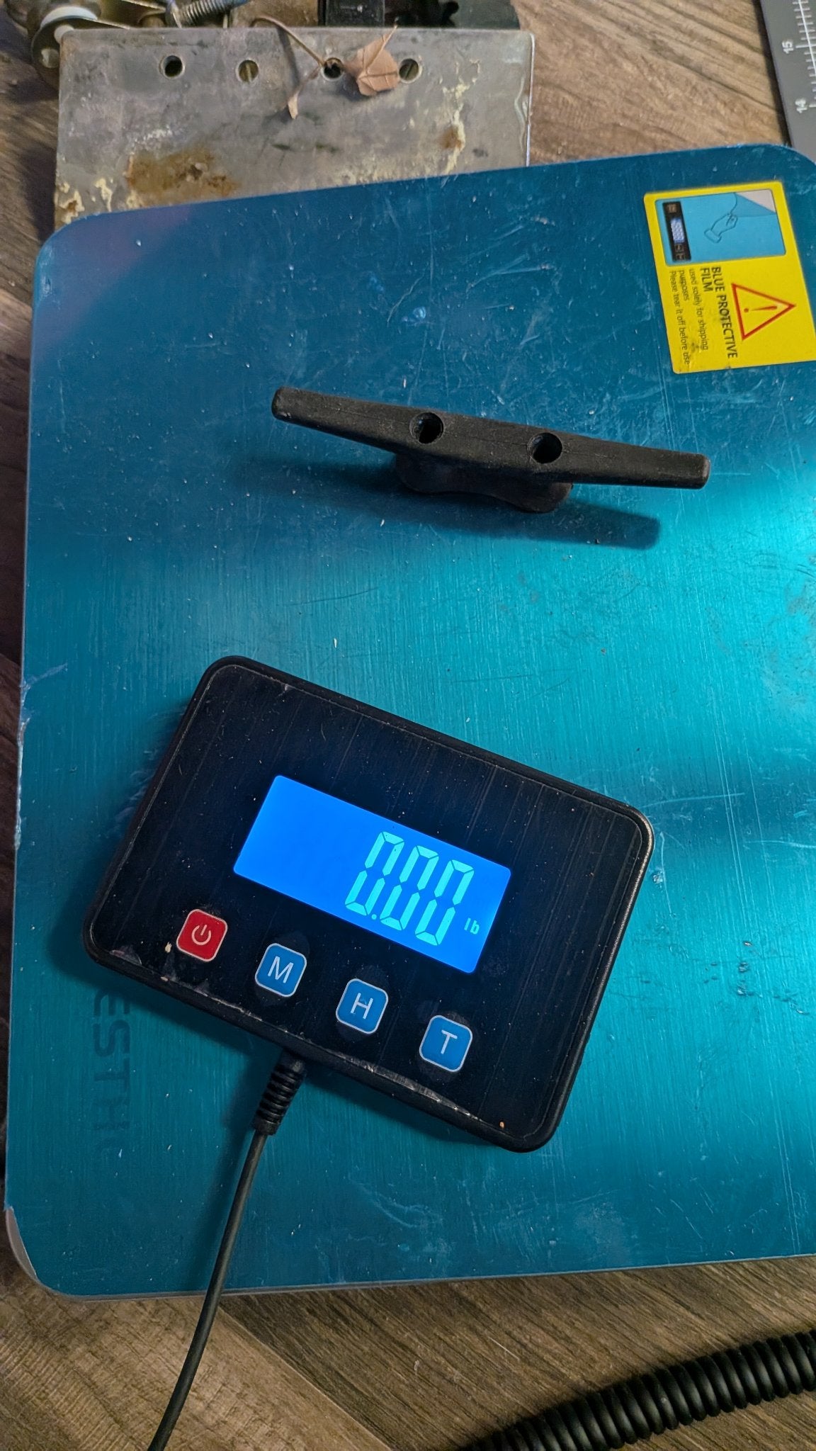 Black nylon dock cleat on scale showing 0.00 lb