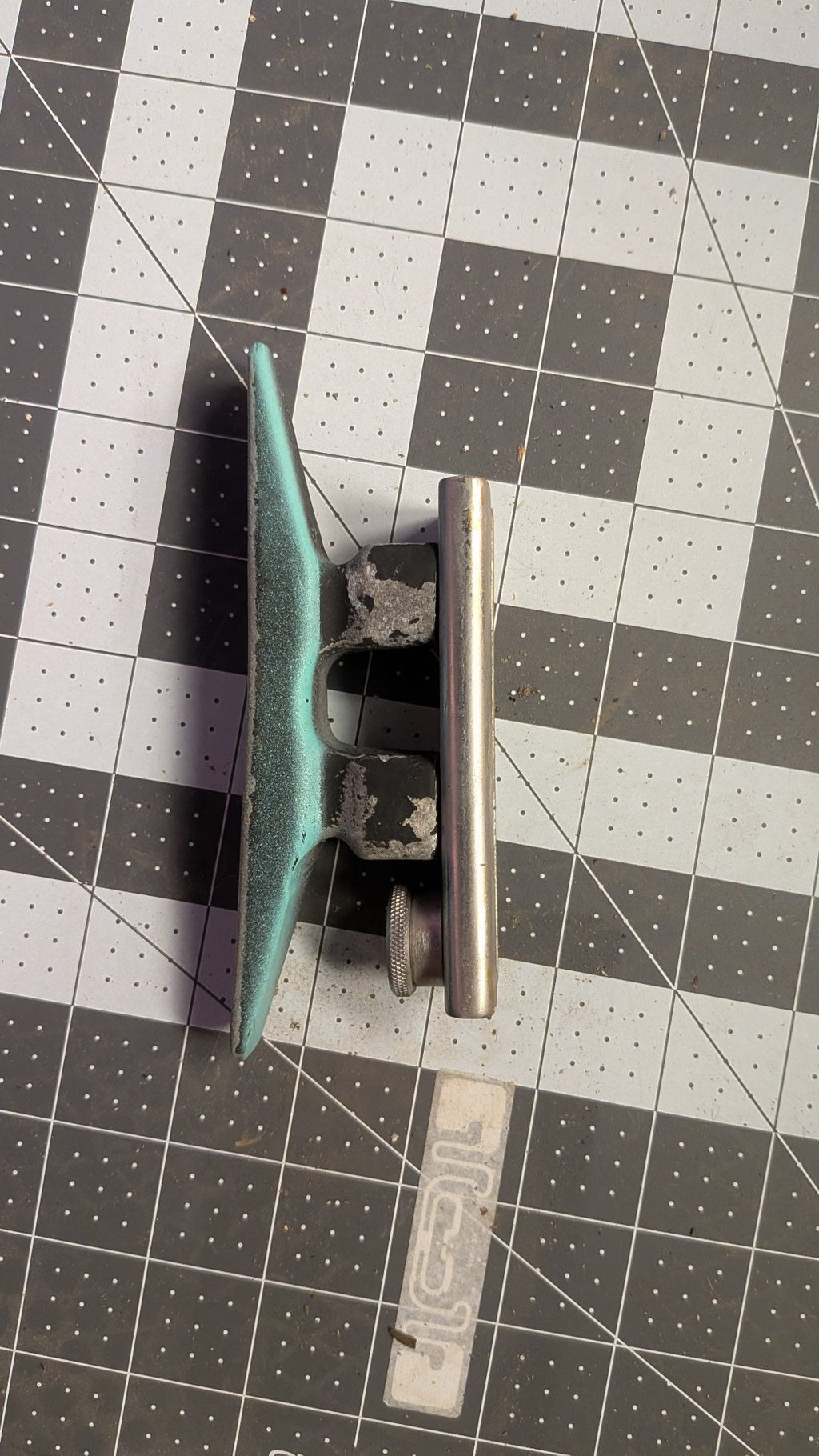 Side view of cleat on T-track slide on 1-inch grid