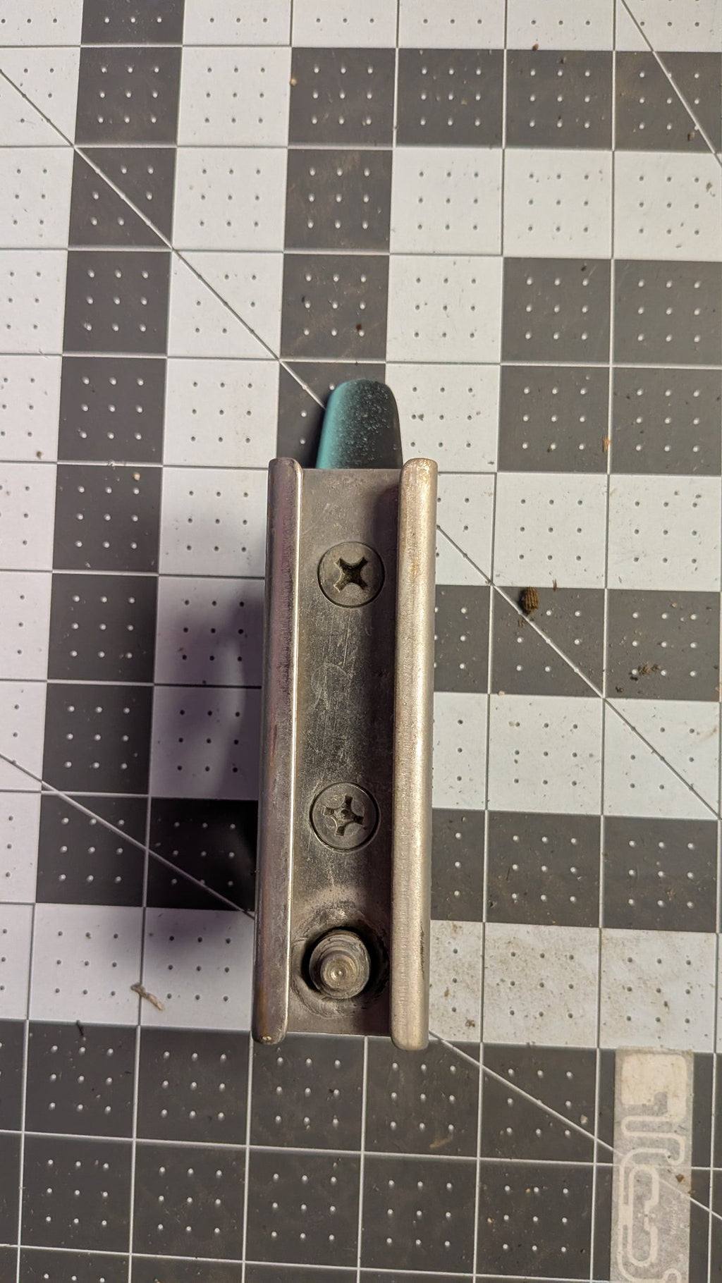 Bottom view of T-track slide with locking knob on 1-inch grid