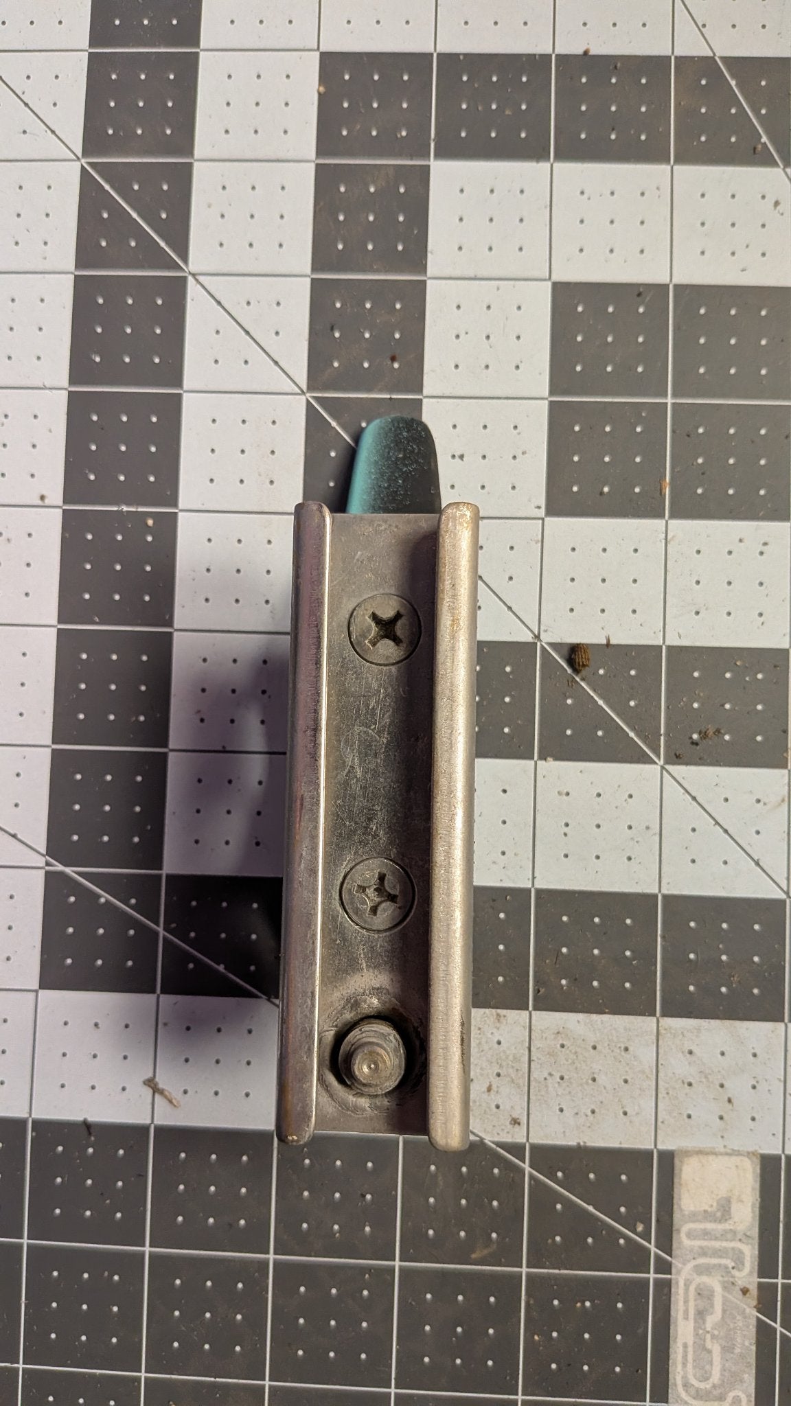 Bottom view of T-track slide with locking knob on 1-inch grid
