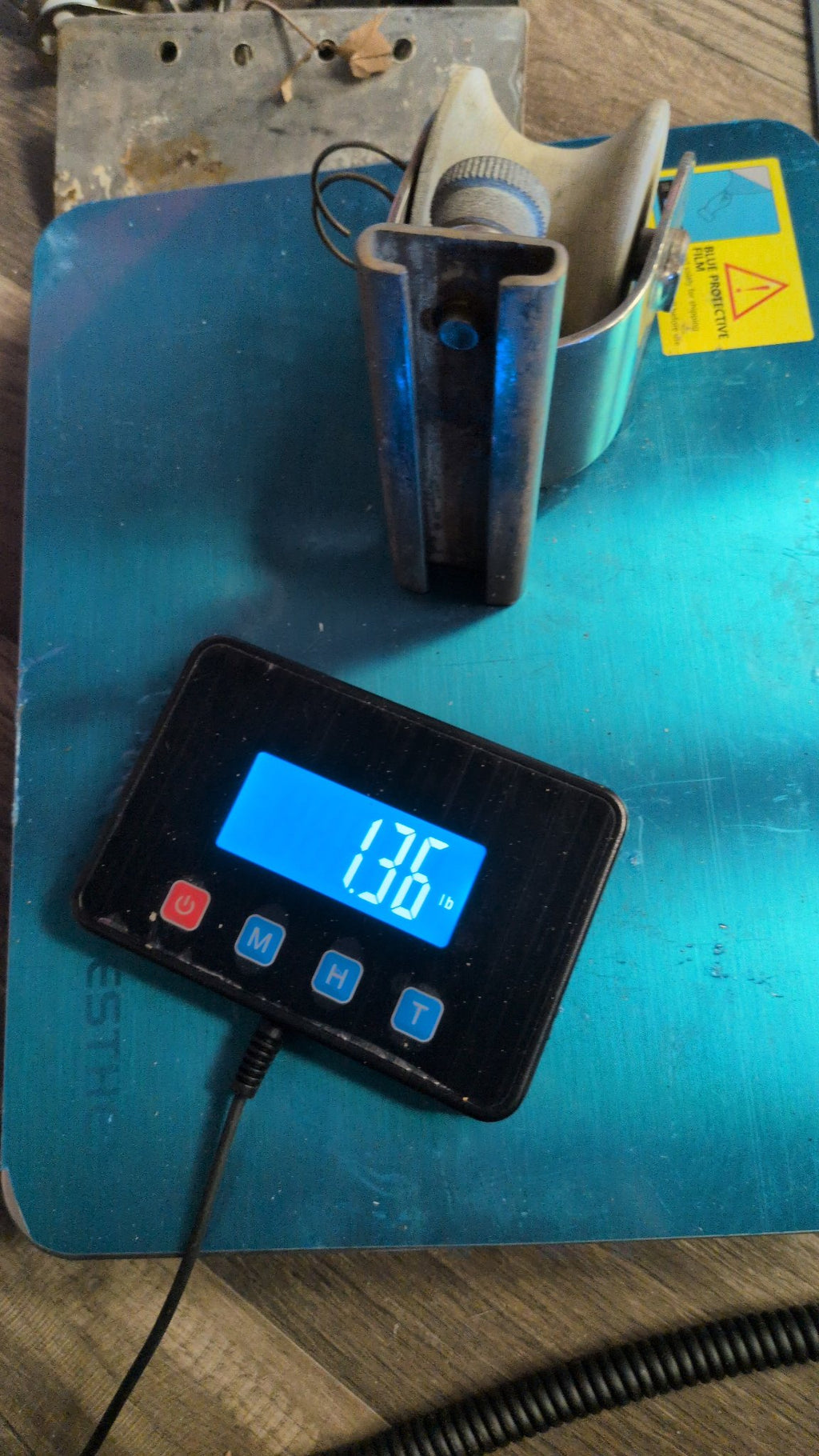 Sheet lead car T-track slide base on scale showing 1.36 lb