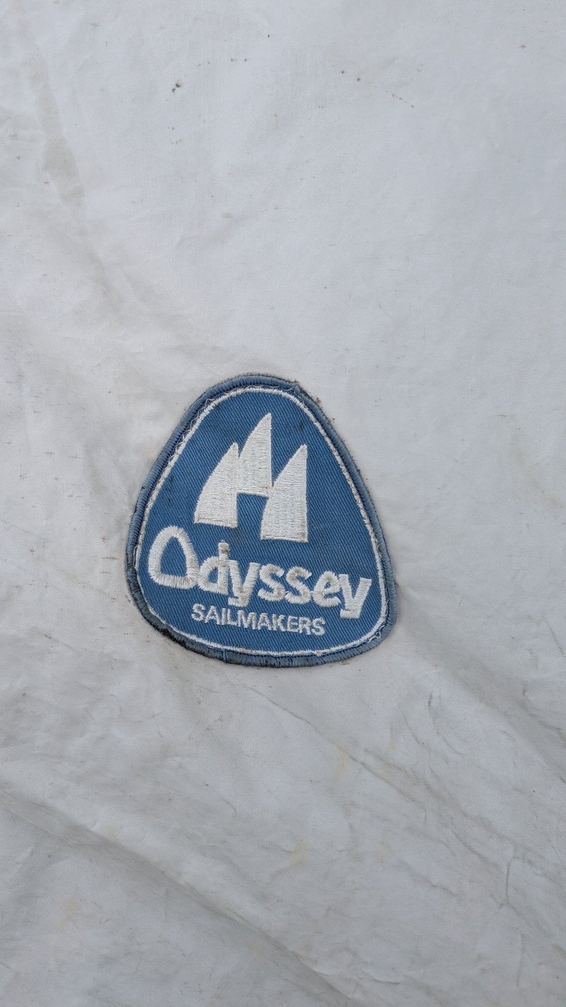 Odyssey Sailmakers logo patch on the sail