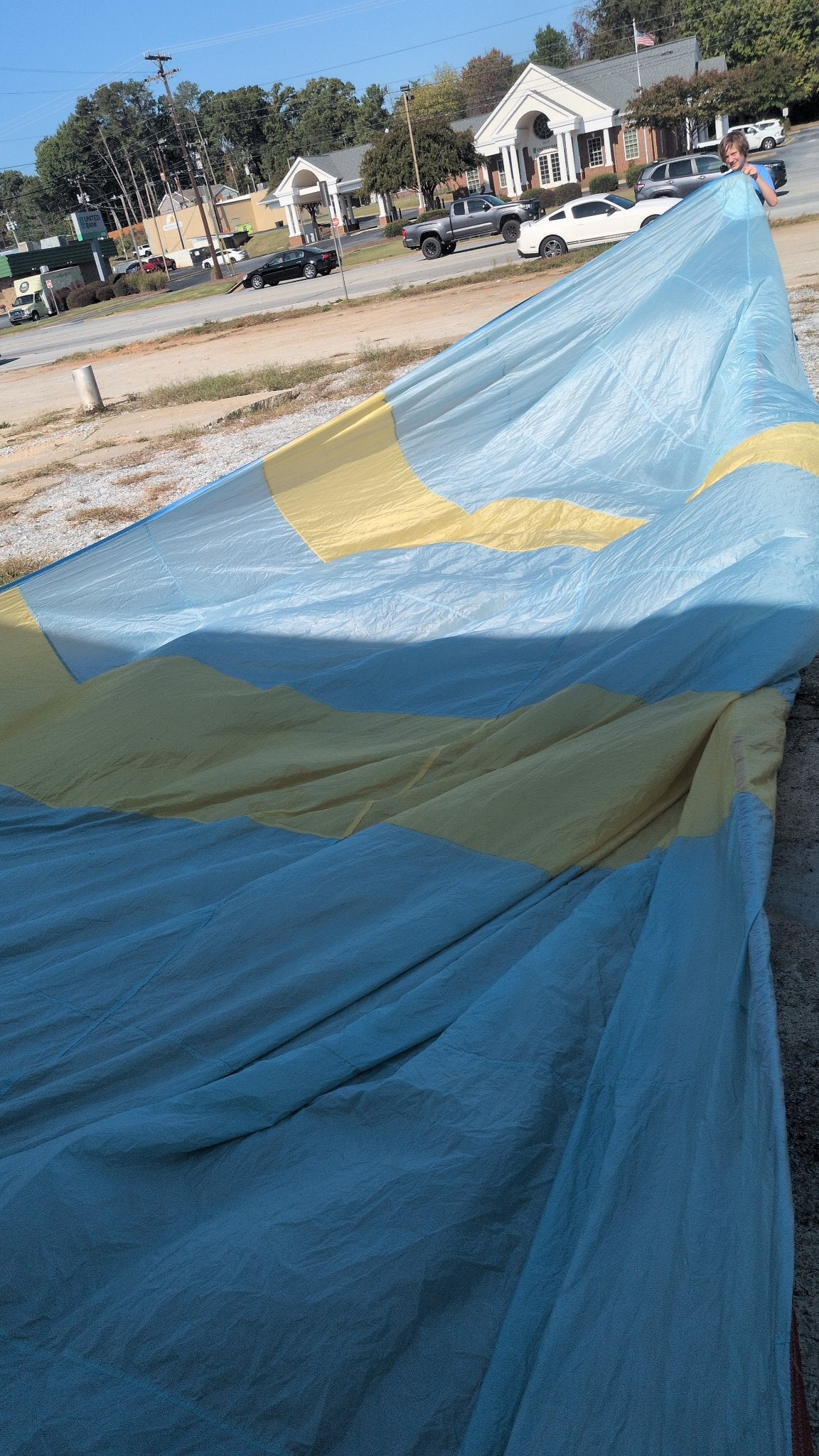 North Sails symmetric spinnaker laid out — light blue with yellow bands, 34 ft 9 in luff