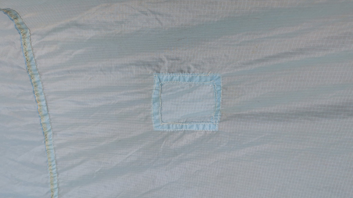 Detail — small sewn patch on the North Sails spinnaker cloth